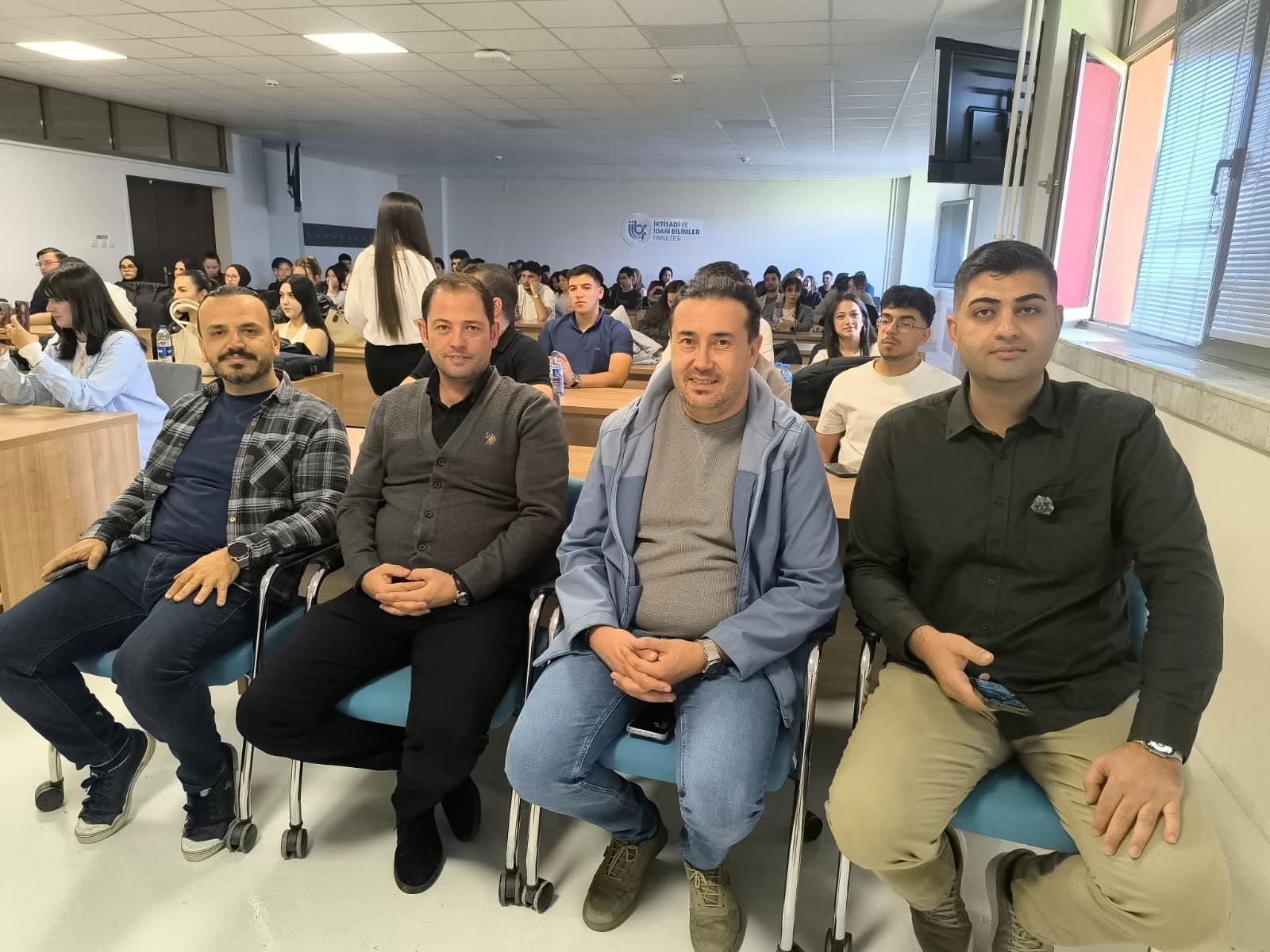 Afyon Kocatepe Üniversitesi'ndeki yapay zekâ seminerinde Auren ekibi, arkada salonu dolduran öğrenciler